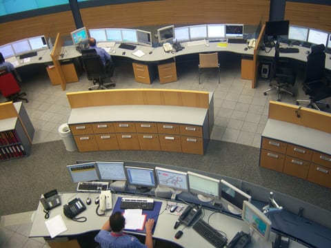 Transit control center with rows of consoles and monitors
