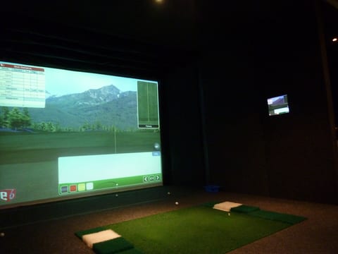 Golf simulator screen with a second TV mounted on the side wall